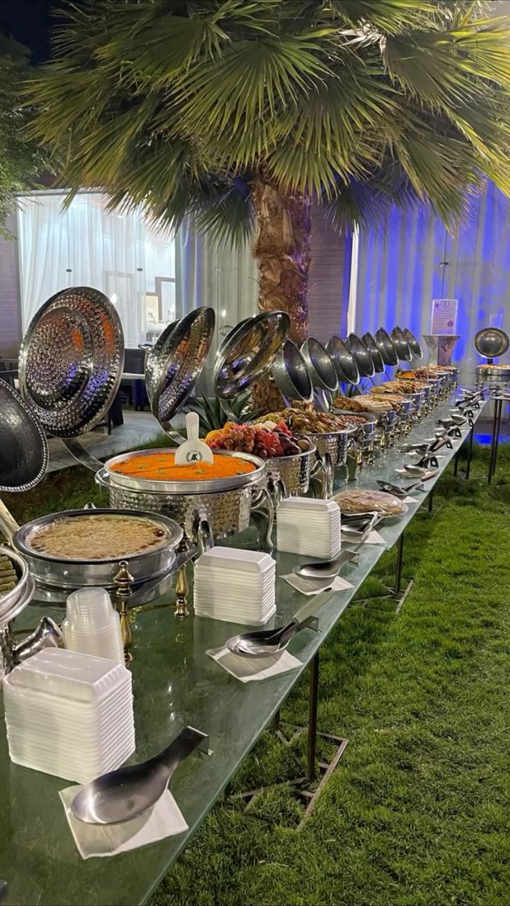 Outdoor buffet set up under palm trees by Negi Catering