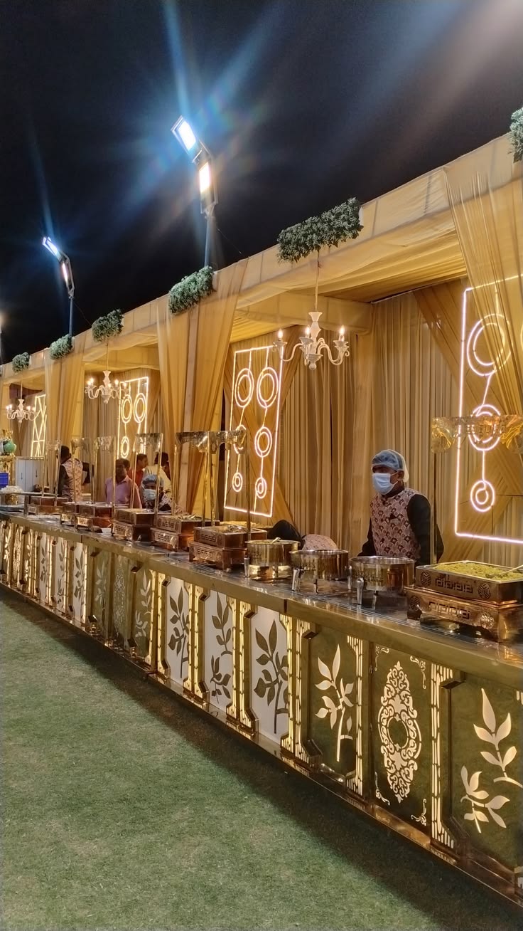 Gold buffet counter set up by Negi Catering at a night wedding